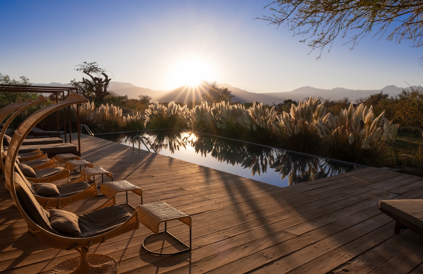 A sunset view over a resort pool and surrounding landscape