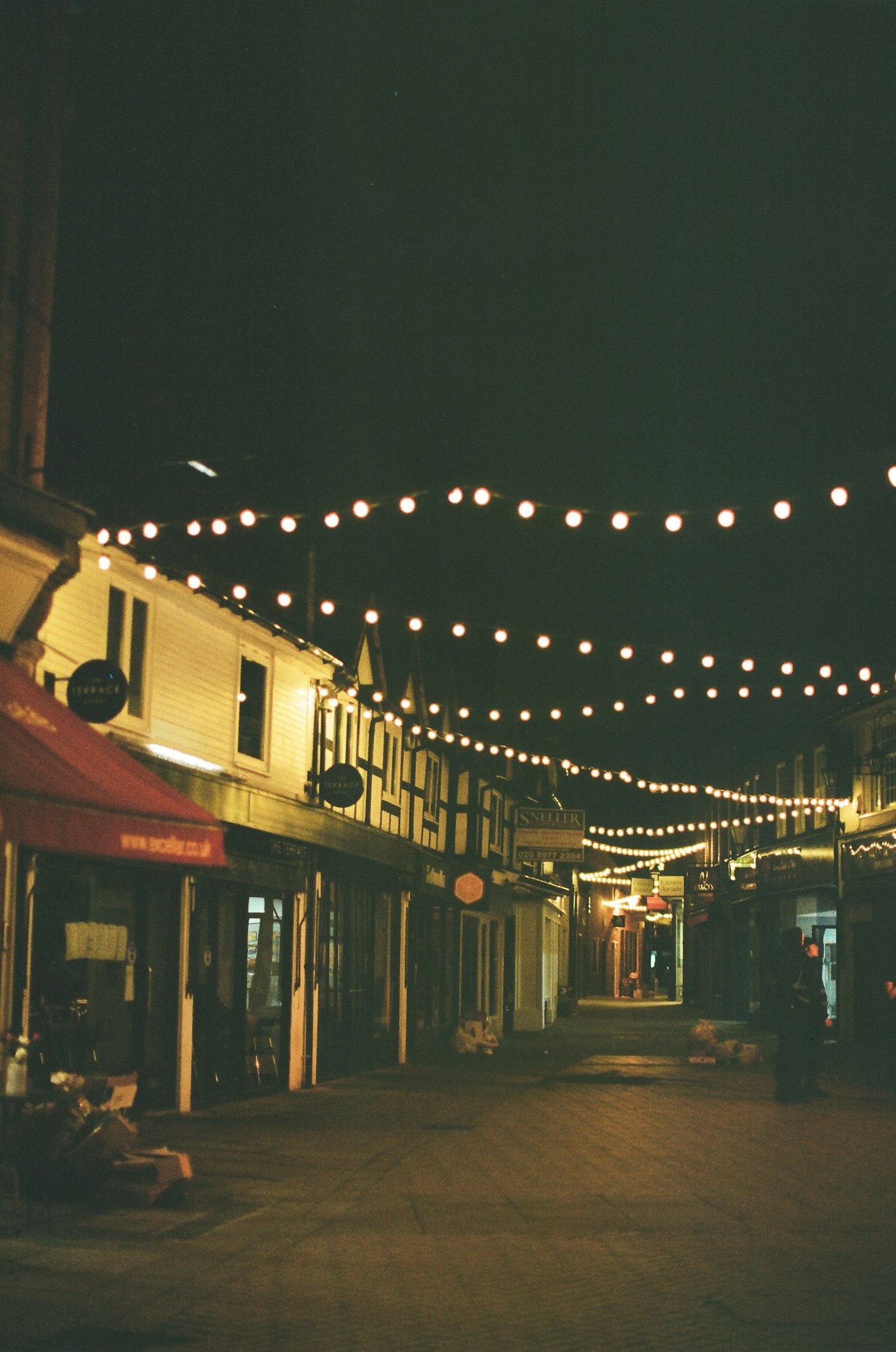 String lights illuminating a charming European village street at night